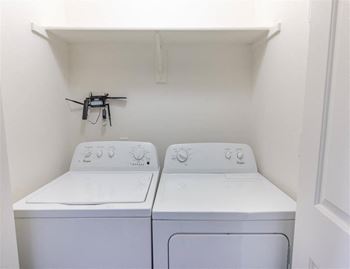 Two white machines in laundry room