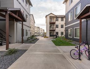 Woodburn apartment for rent - A bicycle is parked on a sidewalk in front of a building.