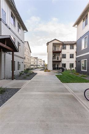 Woodburn apartment for rent - A long concrete walkway separates apartment buildings.