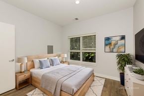 West Lafayette apartment for rent - A bedroom with a large bed and a painting on the wall.