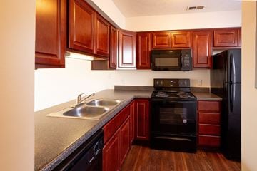 Lafayette apartment for rent - A kitchen with wooden cabinets and black appliances.