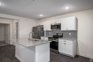 Lafayette apartment for rent - A kitchen with white cabinets and a granite countertop.