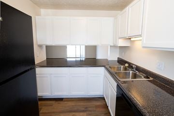 West Lafayette apartment for rent - A kitchen with black fridge and white cabinets.
