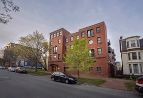 Portland apartment for rent - A tall red brick building with a tree in front of it.