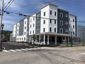 Auburn apartment for rent - A street view of a multi-story building with a crosswalk in front.