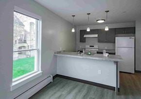 Bath apartment for rent - A kitchen with a white countertop and a window overlooking a green lawn.