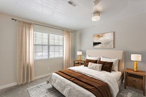 Hixson apartment for rent - A bedroom with a large bed, a nightstand, and a window with curtains.