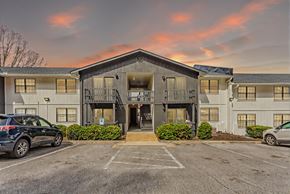 Hixson apartment for rent - A parking lot in front of a building with cars parked.