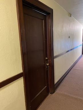 Saint Paul apartment for rent - A brown door is open in a white hallway.