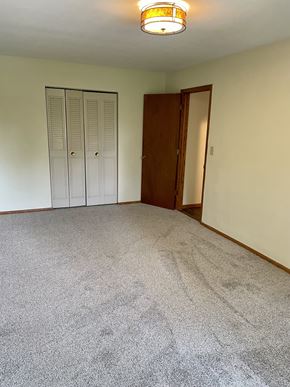 St. Paul apartment for rent - A room with a carpeted floor and a wooden door.