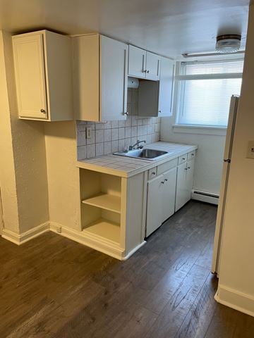 Saint Paul apartment for rent - A kitchen with white cabinets and a wooden floor.