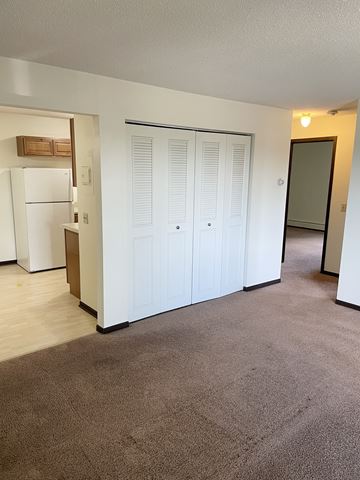 Elk River apartment for rent - A white refrigerator is in a kitchen next to a white door.
