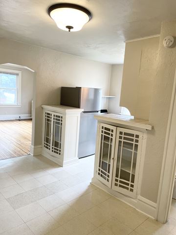 Saint Paul apartment for rent - A kitchen with white cabinets and a black fridge.