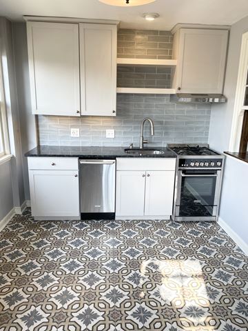 St. Paul apartment for rent - A kitchen with a patterned floor and white cabinets.