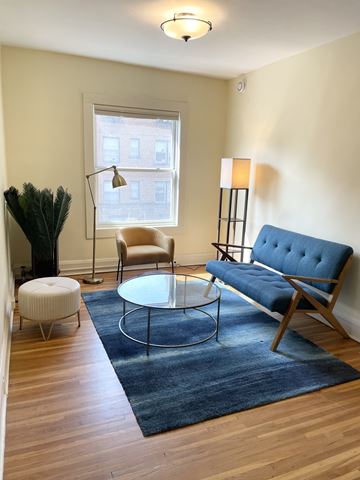 St. Paul apartment for rent - A blue sofa sits in a living room with a glass table in front of it.