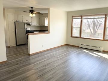 Fridley apartment for rent - A kitchen with a refrigerator, cabinets, and a ceiling fan.