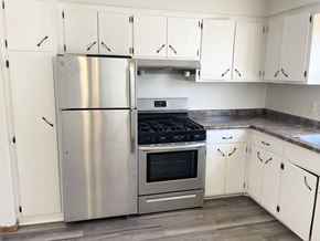 Fridley apartment for rent - A kitchen with a stainless steel refrigerator, oven, and cabinets.