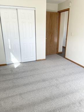 Fridley apartment for rent - A room with a carpeted floor and a white door.