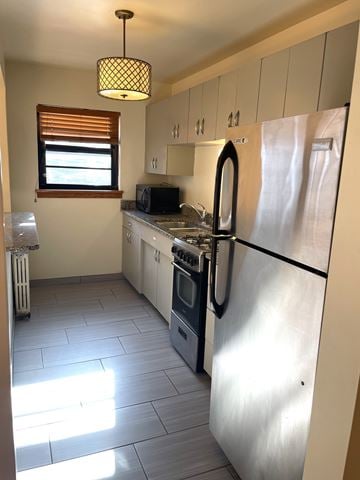 St. Paul apartment for rent - A kitchen with a stainless steel refrigerator and a window with blinds.