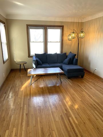 St. Paul apartment for rent - A living room with a blue couch and a wooden floor.