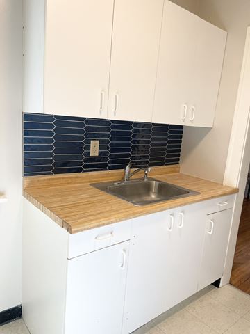 Saint Paul apartment for rent - A kitchen with white cabinets and a wooden counter top.