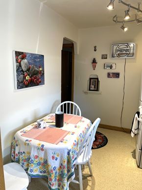 St. Paul apartment for rent - A dining room with a floral tablecloth and a painting of rocks on the wall.