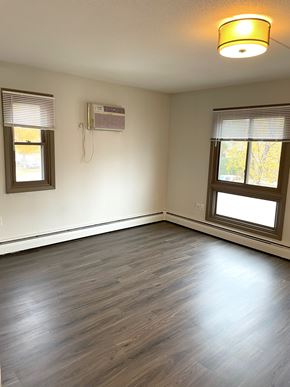 Minneapolis apartment for rent - A room with a window and a wall-mounted air conditioner unit.