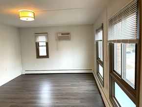 Minneapolis apartment for rent - A room with wooden floors and a window with blinds.