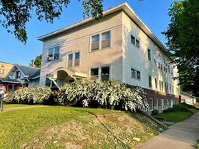 St. Paul apartment for rent - A two-story building with a white exterior and a large bush in front of it.