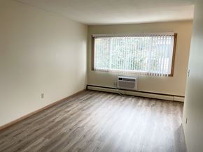 Fridley apartment for rent - A room with a window and a wall-mounted air conditioner.