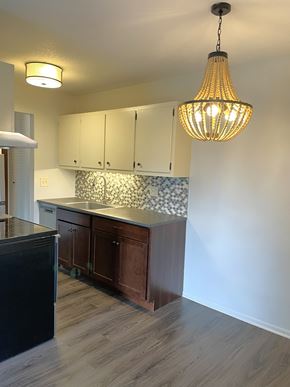 Minneapolis apartment for rent - A kitchen with a black fridge and wooden cabinets.