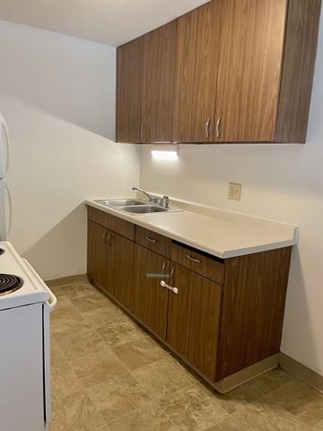 St. Paul apartment for rent - A kitchen with brown cabinets and a white dishwasher.