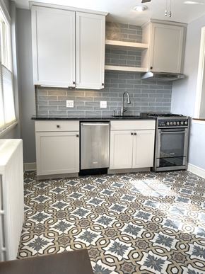 St. Paul apartment for rent - A kitchen with a patterned floor and white cabinets.
