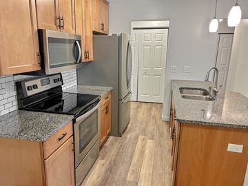 New Hope apartment for rent - A kitchen with wooden cabinets and a granite countertop.
