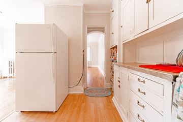 St. Paul apartment for rent - A white refrigerator in a kitchen with wooden floors and white cabinets.