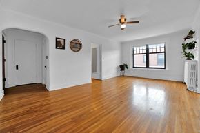 St. Paul apartment for rent - A room with a wooden floor and a ceiling fan.
