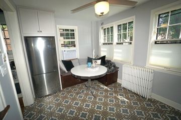 St. Paul apartment for rent - A kitchen with a refrigerator, a table with a white tablecloth and a ceiling fan.