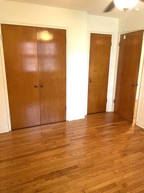 St. Paul apartment for rent - Three brown doors in a white room with wood floors.