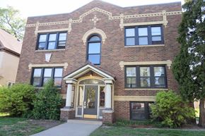 Minneapolis apartment for rent - A red brick building with a large arched window and a doorway.