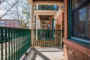 St. Paul apartment for rent - A green fence is in front of a red brick building.