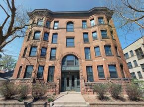 St. Paul apartment for rent - A red brick building with a large arched entrance and a stone wall.