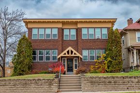 St. Paul apartment for rent - A two-story brick house with a front porch and stairs leading up to the entrance.