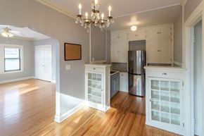 Minneapolis apartment for rent - A kitchen with wooden floors and white cabinets.