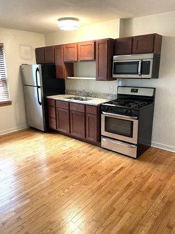 St. Paul apartment for rent - A kitchen with wooden floors and brown cabinets.