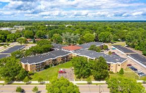 New Hope apartment for rent - A large building surrounded by trees and a parking lot.