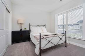 Lewis Center apartment for rent - A bedroom with a black metal bed frame and a white bedspread.