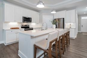 Lewis Center apartment for rent - A kitchen with white cabinets and a long island with chairs.