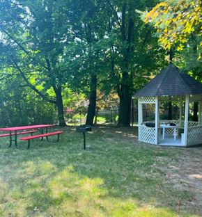 Akron apartment for rent - A gazebo sits in a grassy area with picnic tables and trees.