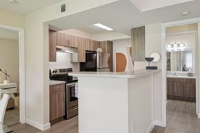 Miami apartment for rent - A kitchen with a white island and wooden cabinets.