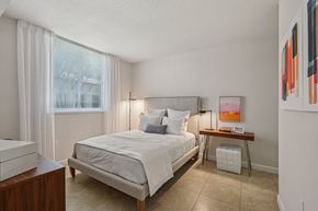 Doral apartment for rent - A bedroom with a large bed and a window with curtains.
